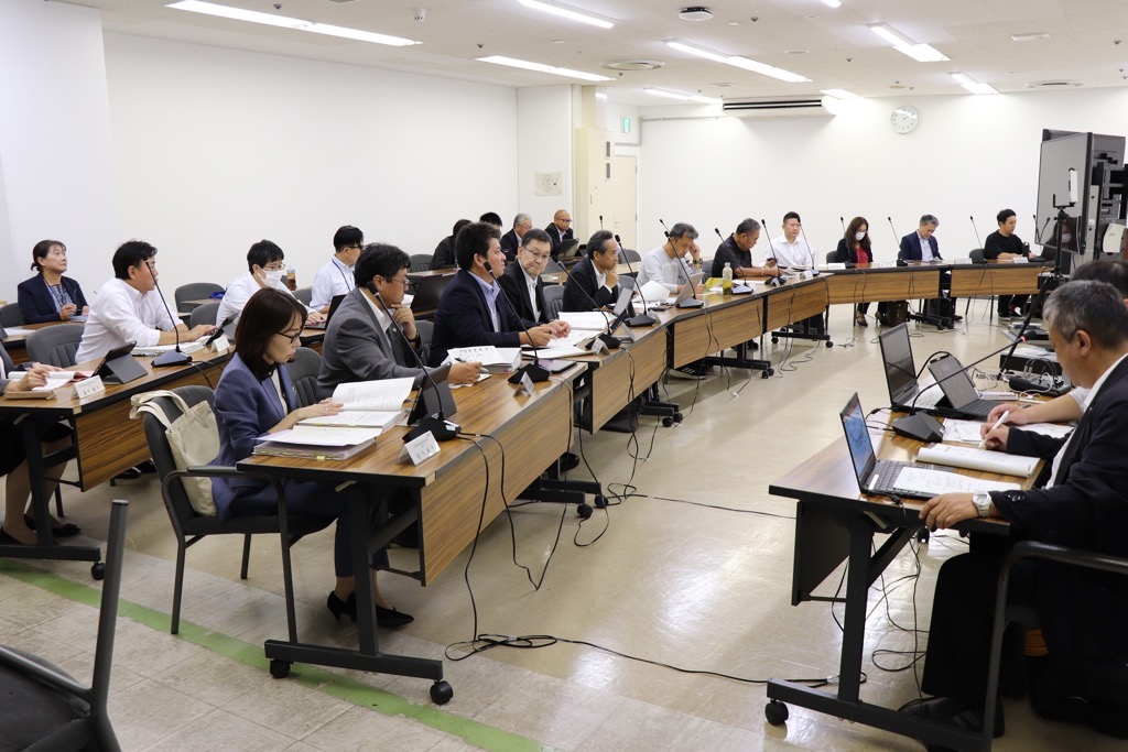 第2回資源循環部会の会議開催中の様子 モニターを軸に半円状に机が並び、委員が座っている