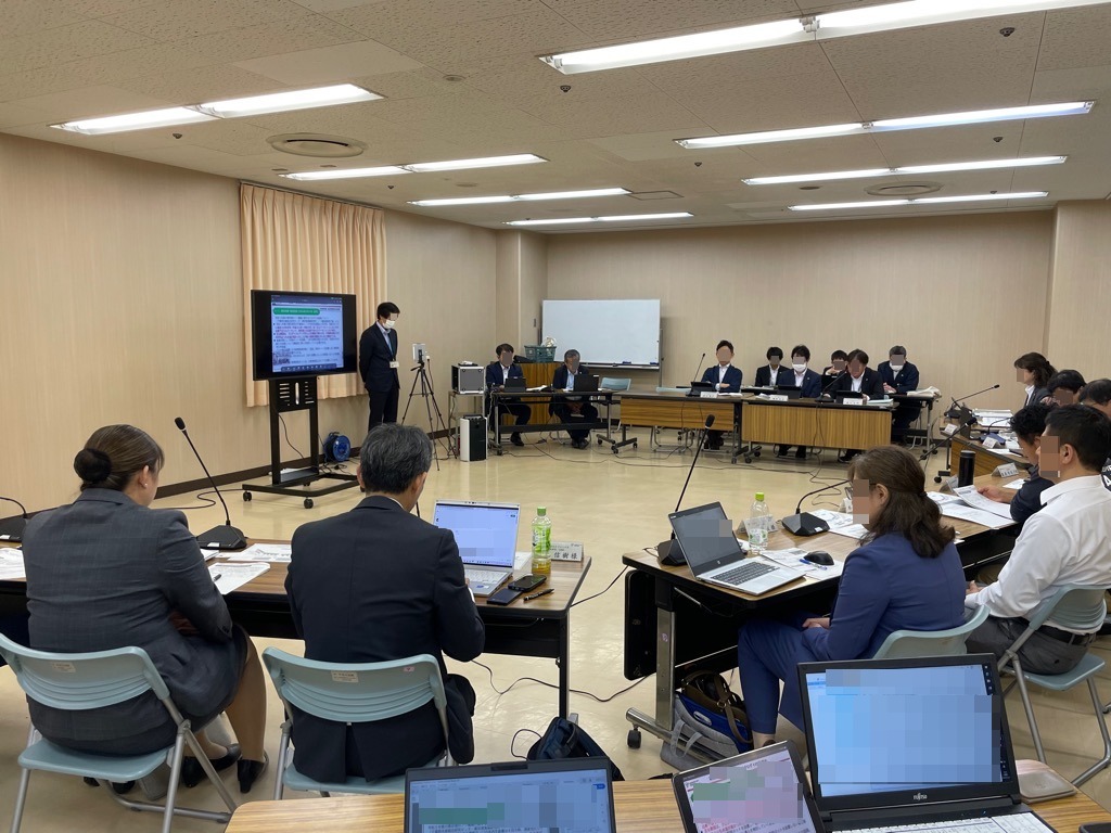 第1回資源循環部会の会議開催中の様子 モニターを軸に半円状に机が並び、委員が座っている