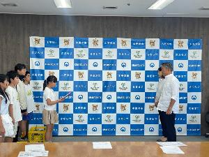 中郷小学校の児童が市長にトウモロコシを贈呈している。