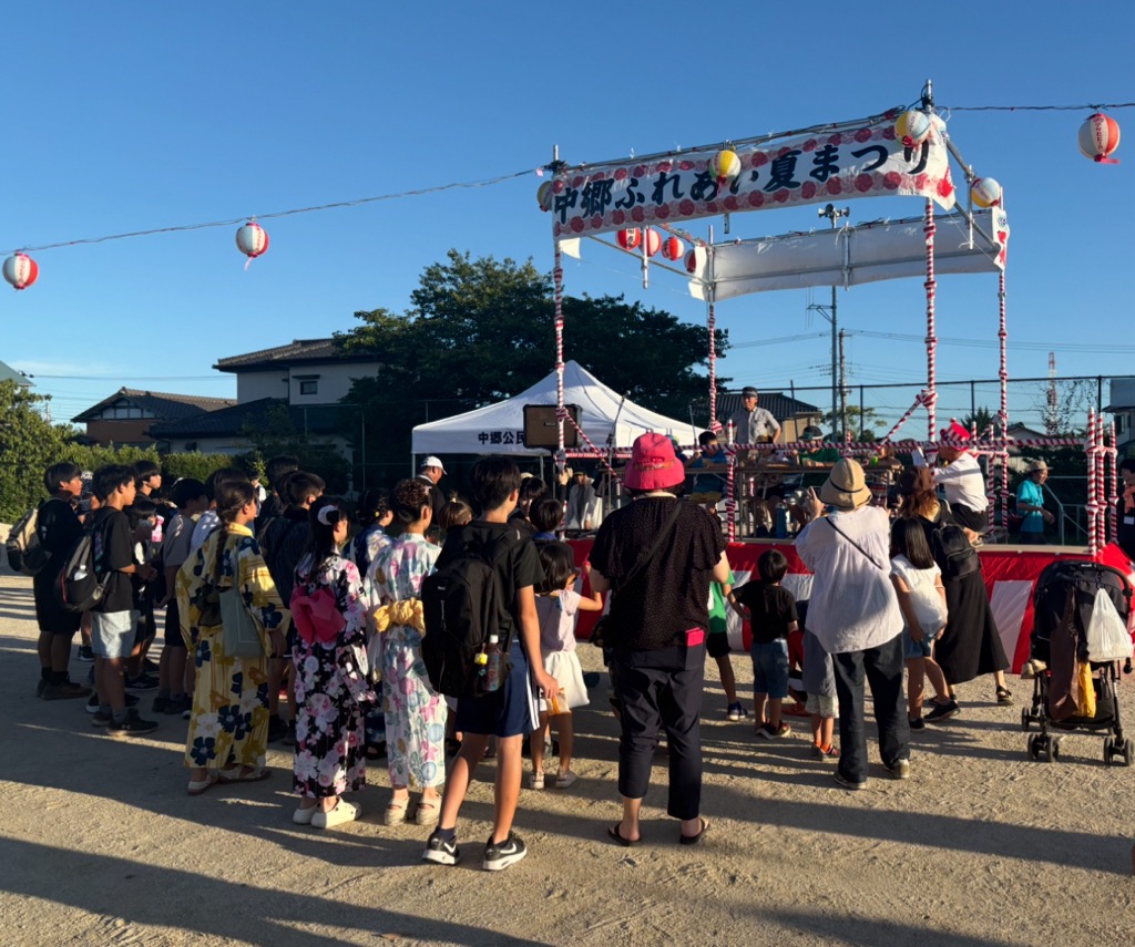 かき氷早食い競争に参加する子供たちとそれらを応援する夏祭り来場者