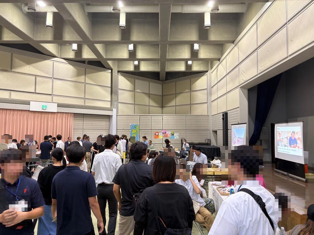 市民ホール内にたくさんの来場者がブースを見て回る様子