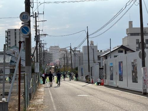 鳥居崎海浜公園近くの道路を職員及び一般ボランティアの方がゴミ袋をもって清掃する様子