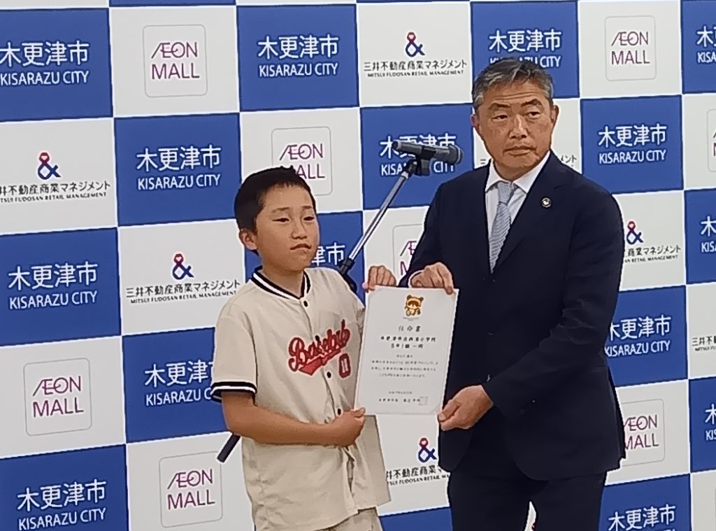 渡辺市長から1組代表児童に任命書を手わてしている写真