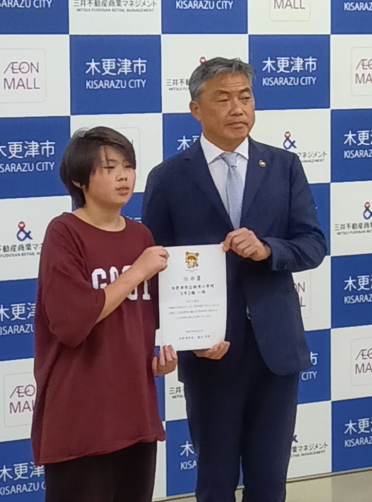 渡辺市長から2組代表児童に任命書を手渡している写真