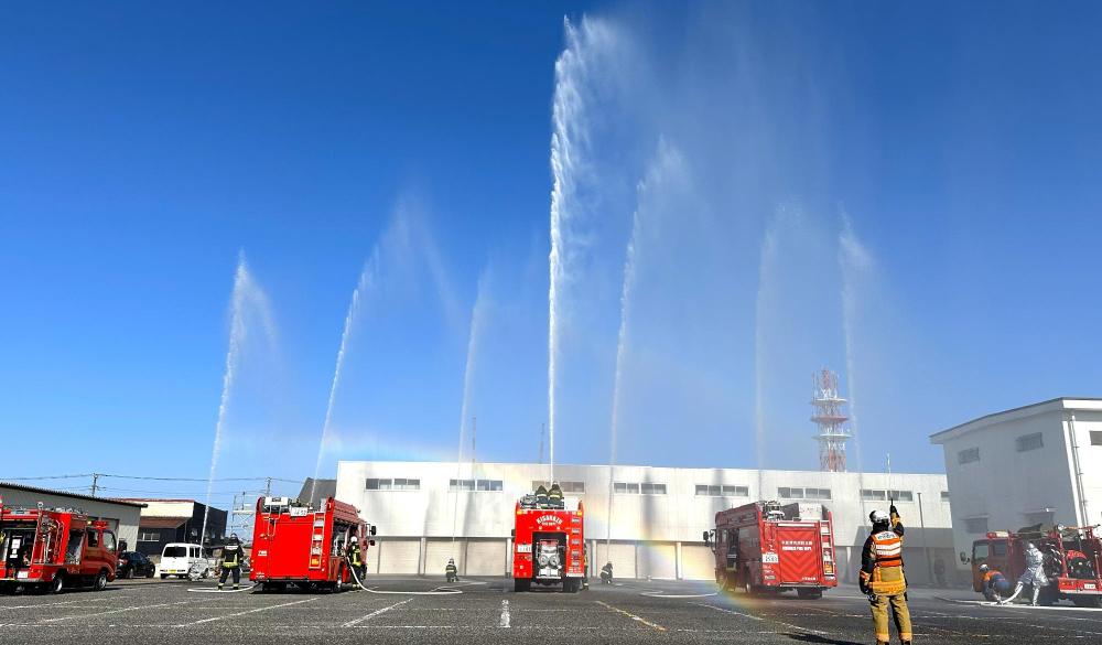 消防車3台と消防士による上空へ放水をしている様子