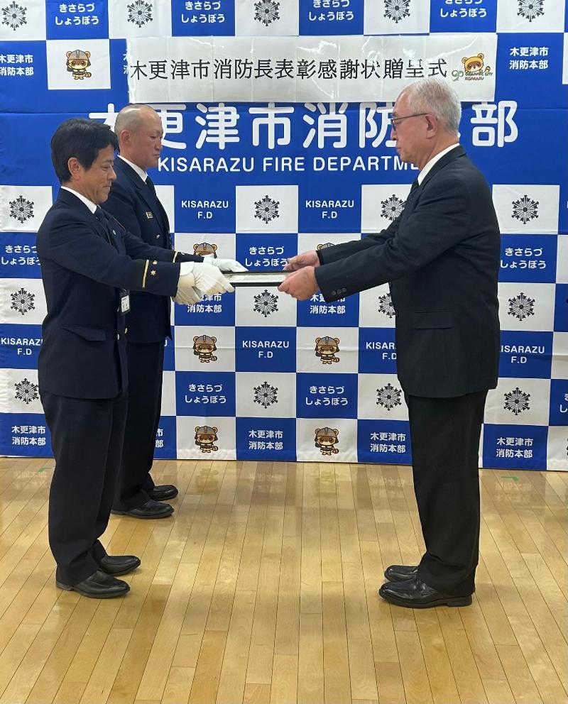 木更津市消防長から感謝状を受賞者(夫)へ渡している