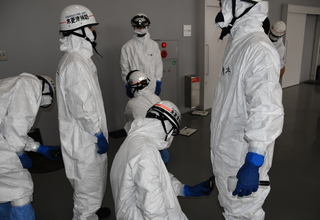 白の防護服を着用した隊員が2名1組になり放射線測定器を用いて訓練を実施している様子の写真