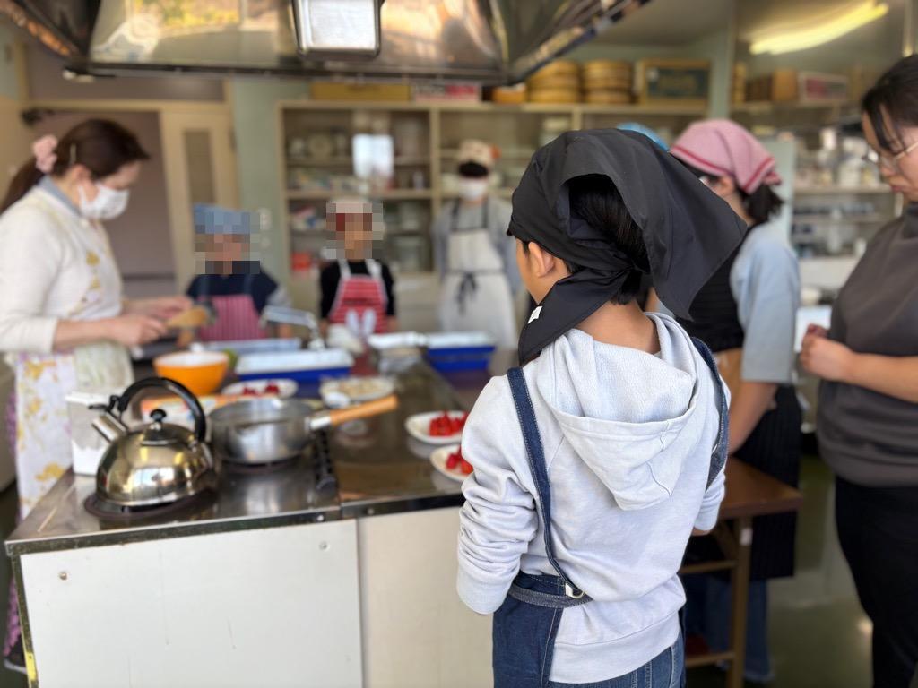 男子参加者が講師のお菓子作りを学ぶ様子。