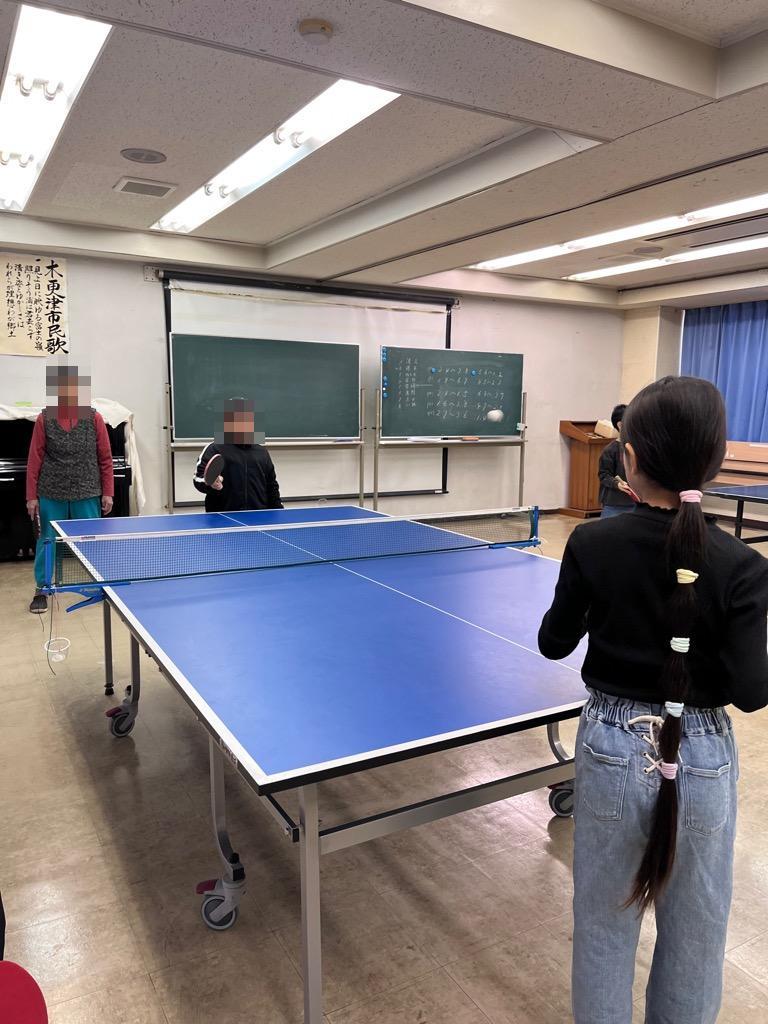 参加者が卓球サークルの人から卓球を教わる様子。