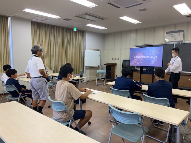 中学生が講師から使い方を教わる様子です。