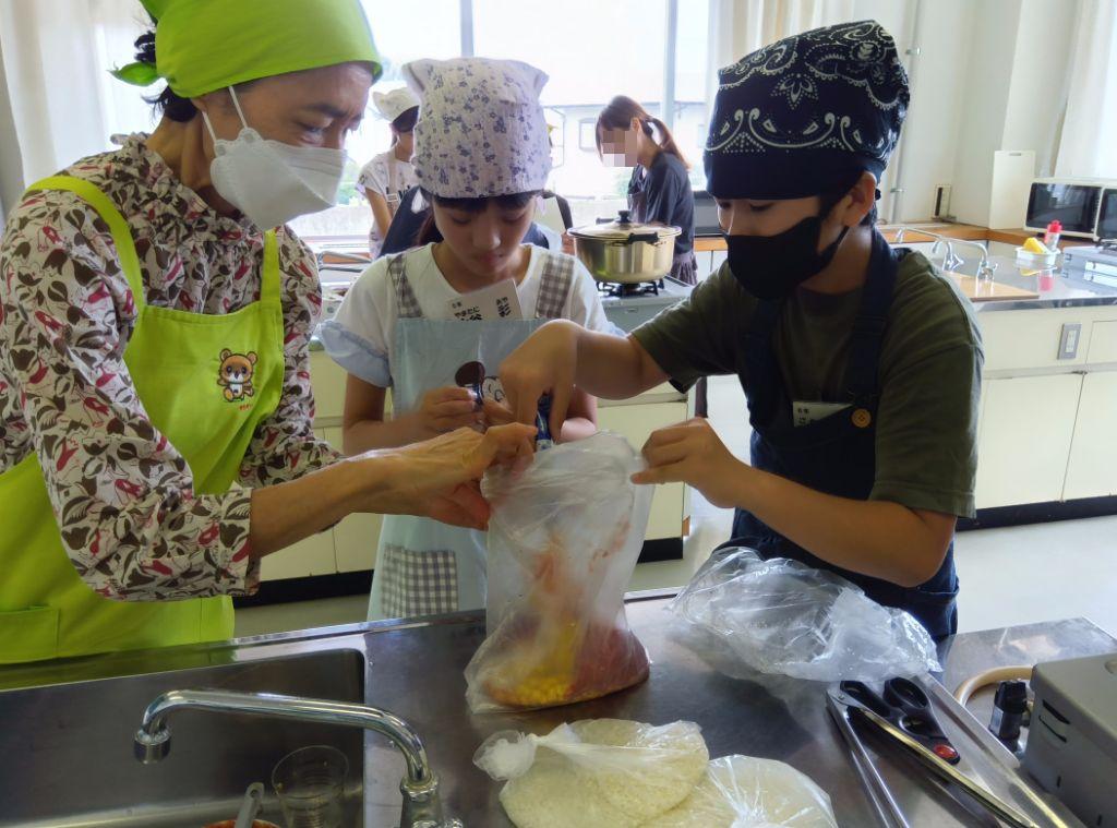 キッズわくわく体験隊の子どもたちが、食生活サポーターの講師の方に教わりながら協力して防災食を調理する様子。