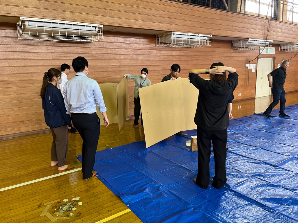 市の職員が避難所用の間仕切りダンボールを組み立てている様子