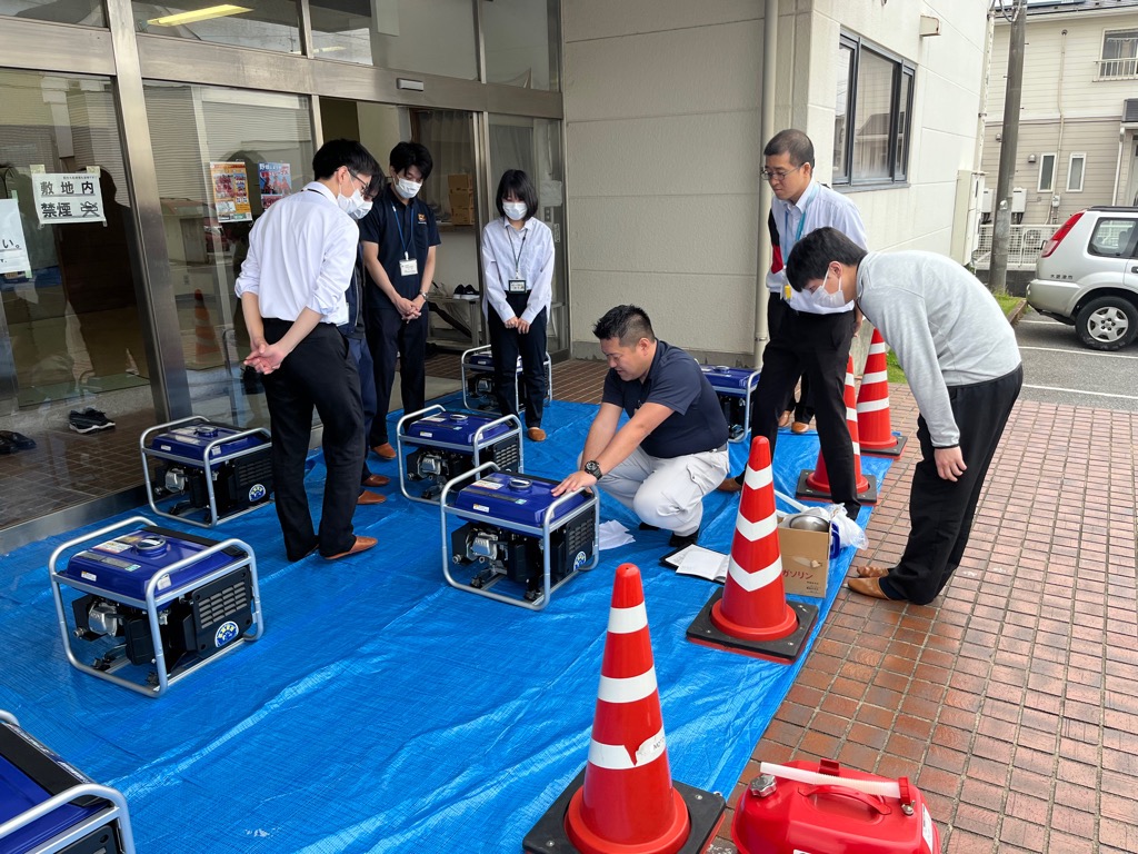 市の職員が発動発電機の操作要領を実習している様子