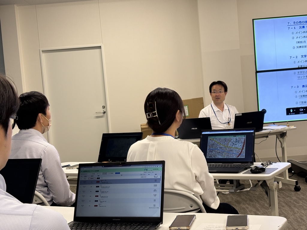 危機管理官が災害用システムの運用方法を説明している様子