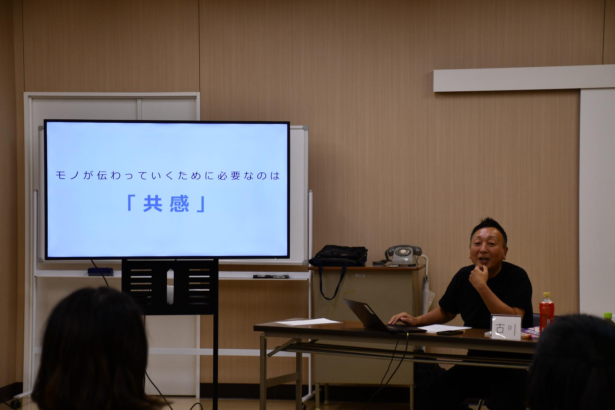 講師がモニターを見ながら笑顔で話す様子