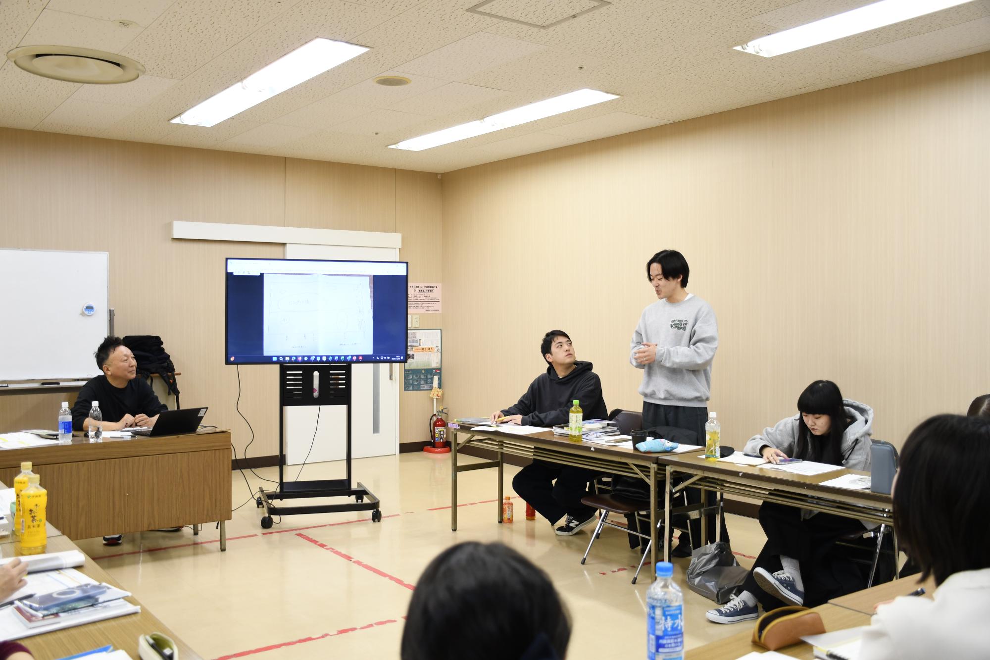 市民ライターが立って発表して周りが聞いている様子