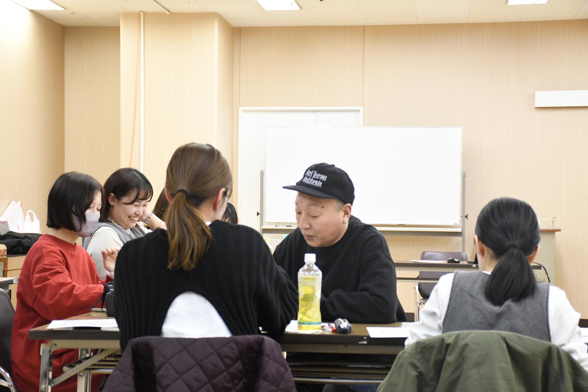 市民ライターと講師が机を挟んで話し合っている様子