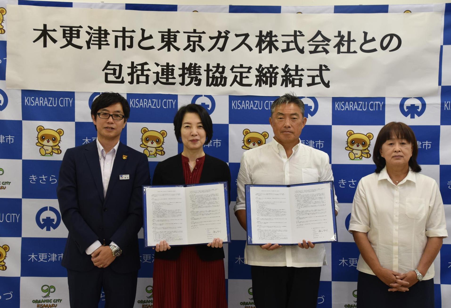 木更津市のバックボードの前で、中央から左に協定書を持つ東京ガス常務執行役員 地域共創カンパニー長 小西様、千葉支社長 清田様、中央から右に協定書を持つ渡辺市長、田中副市長が並んだ記念写真