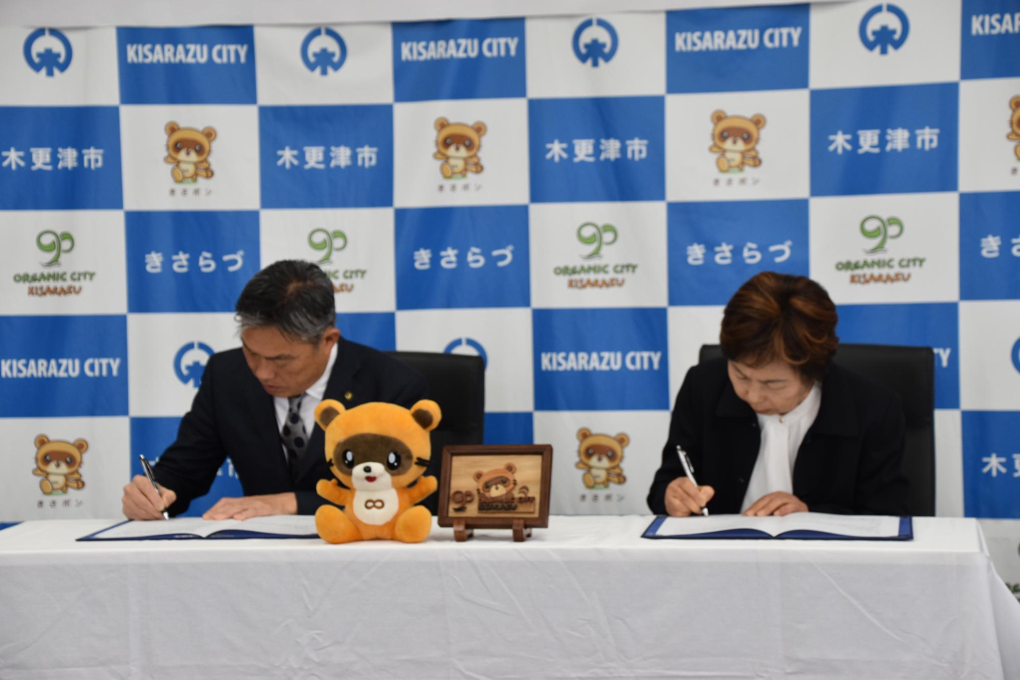 署名をする渡辺市長と飯田理事長