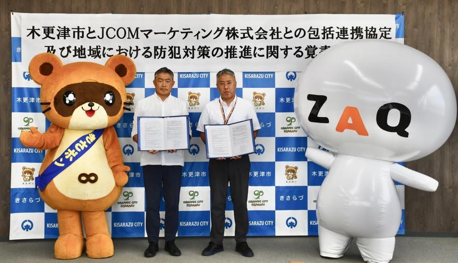 左から、木更津市マスコットキャラクターきさポン、協定書を手に持つ木更津市長およびJCOMマーケティング株式会社木更津オフィス越路局長、JCOMキャラクターざっくぅ