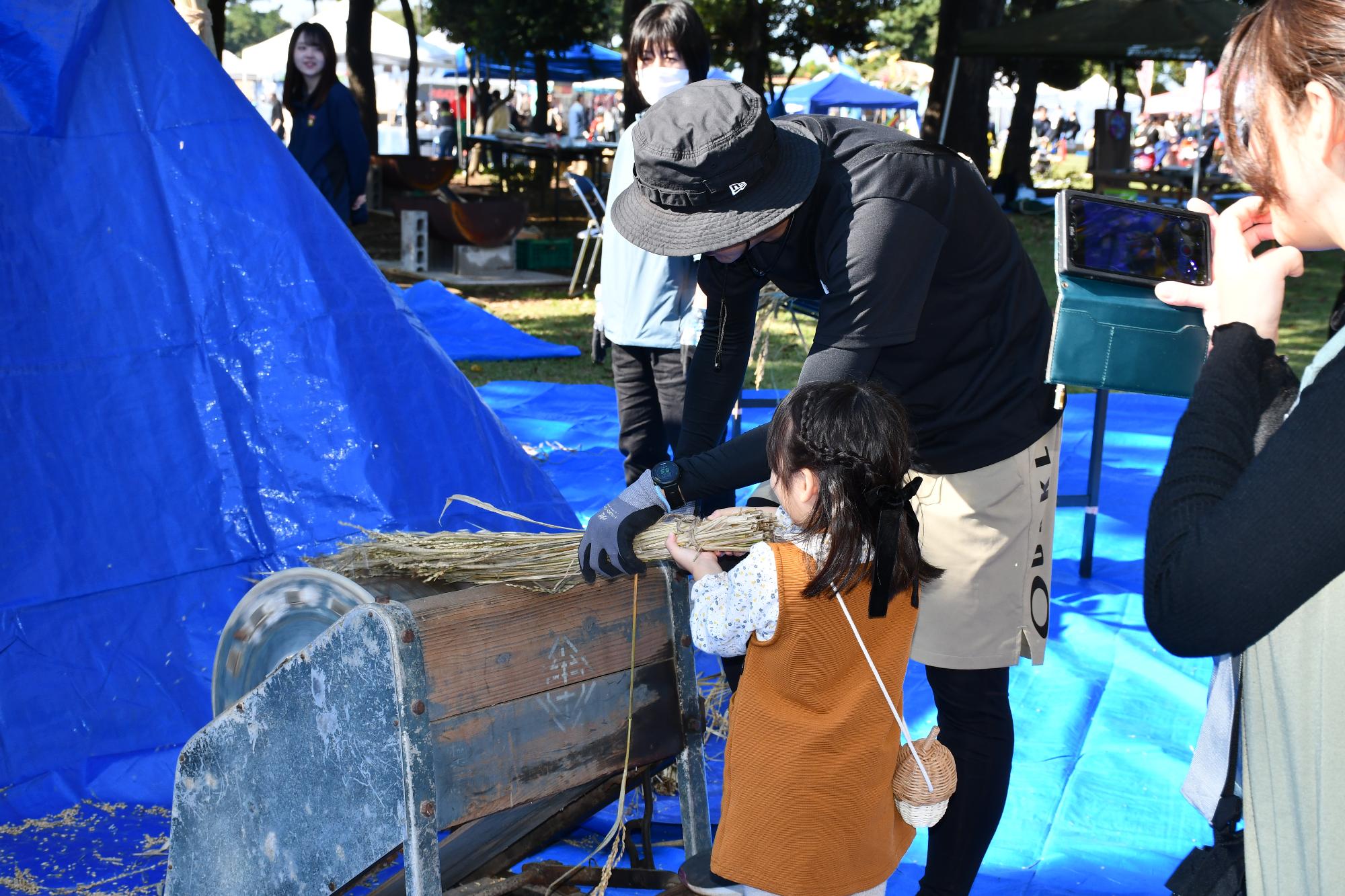 脱穀体験をする子ども