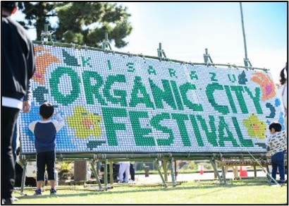 ペットボトルキャップアートでKISARAZU ORGANIC CITY FESTIVALと書いてある看板
