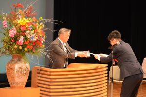 二十歳を祝う会実行委員長から市長に二十歳代表者誓いの言葉を渡す様子の写真