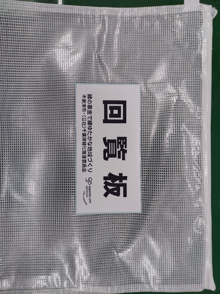 緑化推進PR事業の一環として、「緑の募金で緑豊かな地域づくり 木更津市・（公社）千葉県緑化推進委員会と」名入れした回覧板用ポーチの写真