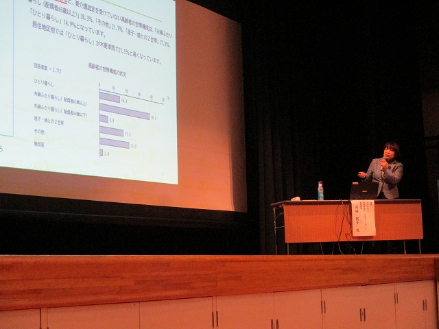 壇上で講師が講演会をしている様子