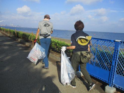 潮浜公園の海沿いの道をボランティア清掃参加者が清掃する様子