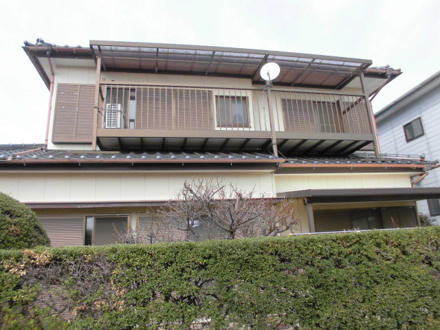 玄関前に庭木が植えられ、白を基調とした外壁で三角屋根をした物件（A028）の外観写真