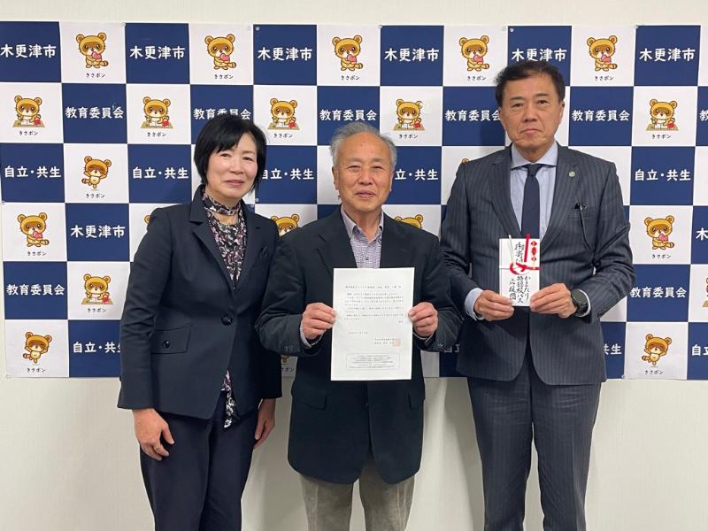 鎌足地区まちづくり協議会の寄附採納を行った際の記念写真（右から廣部教育長、市川会長、山村館長）