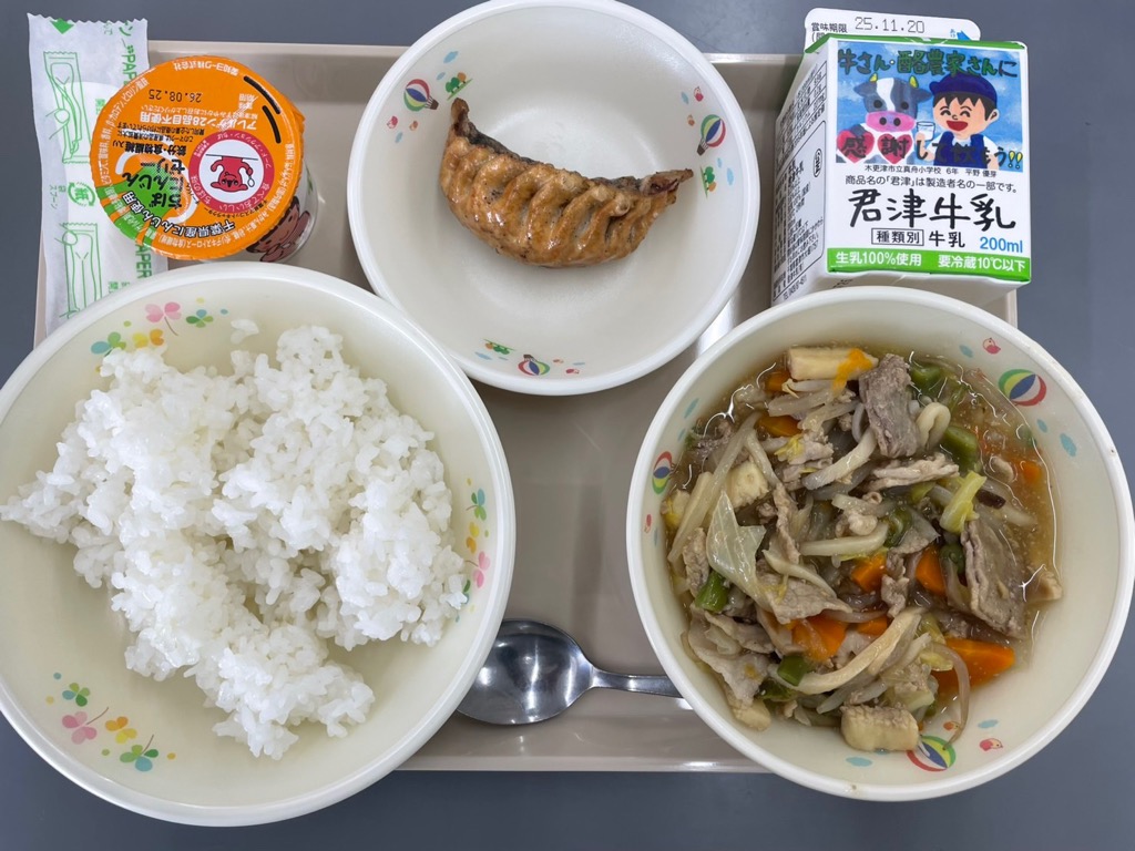 トレーにきさらづ学校給食米のごはん、中華丼の具、ビッグ餃子、千葉県産人参ゼリー、牛乳が乗っている写真