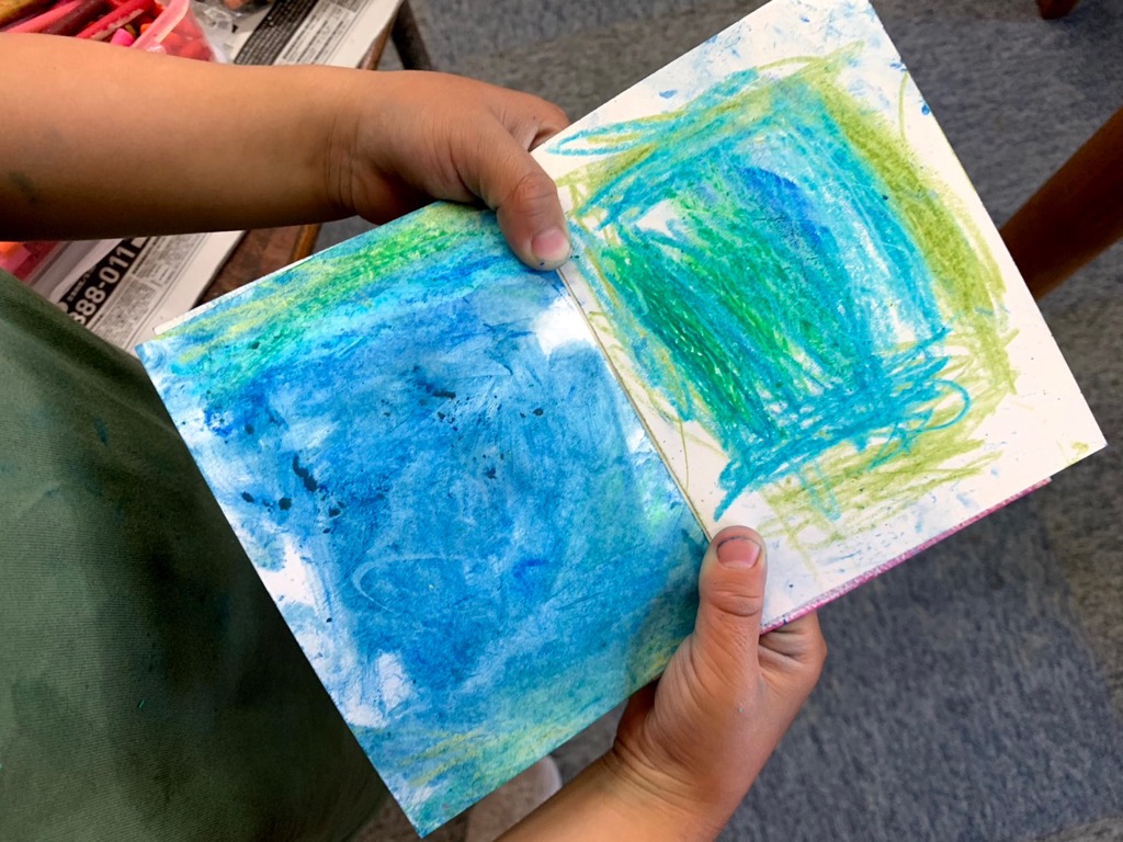 こどもの手が色のついた画用紙を持っている写真