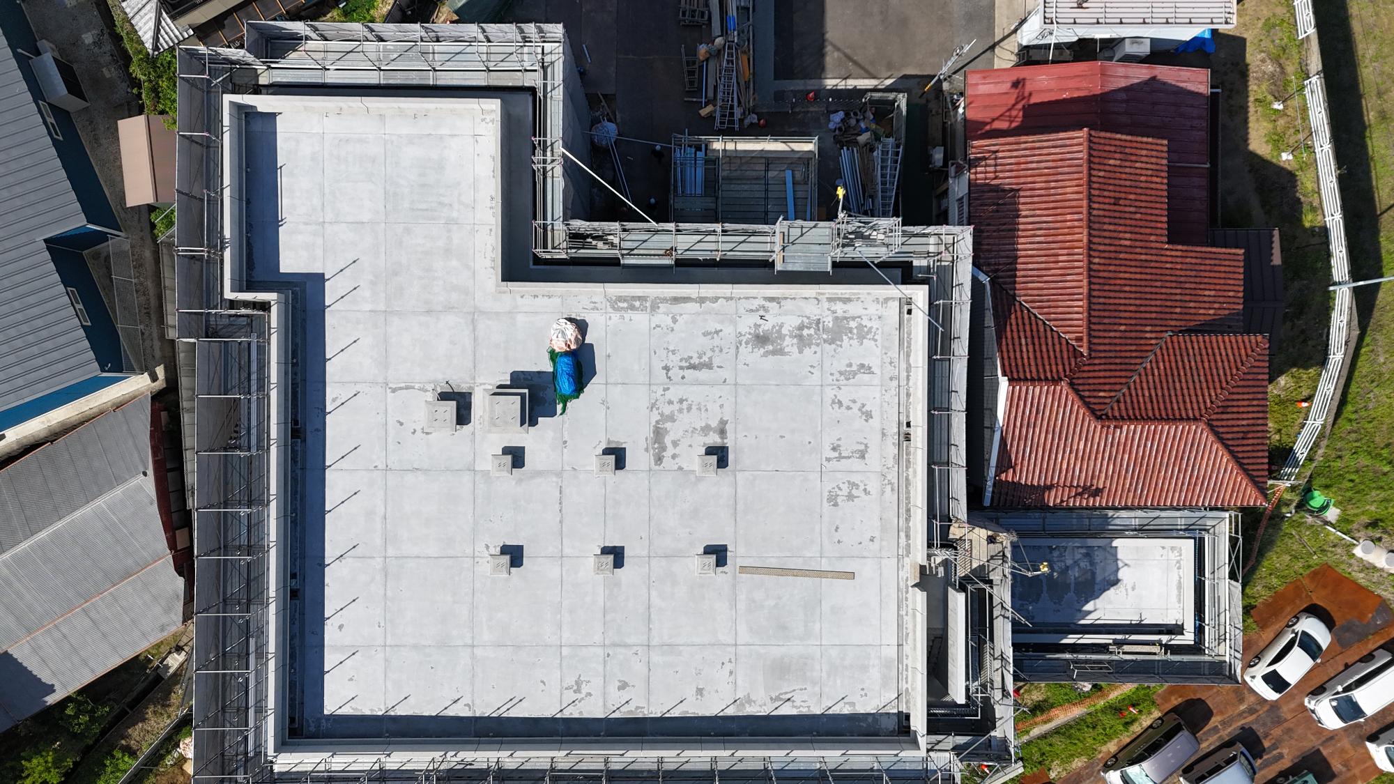 令和8年5月11日時点の建設工事の状況を上空からドローンで撮影した写真。建設中の庁舎棟の屋上は太陽光発電設備を設置するための基礎が6か所ありその他無線設備基礎が2か所設置されている。庁舎棟右側には発電機室の工事が行われている。