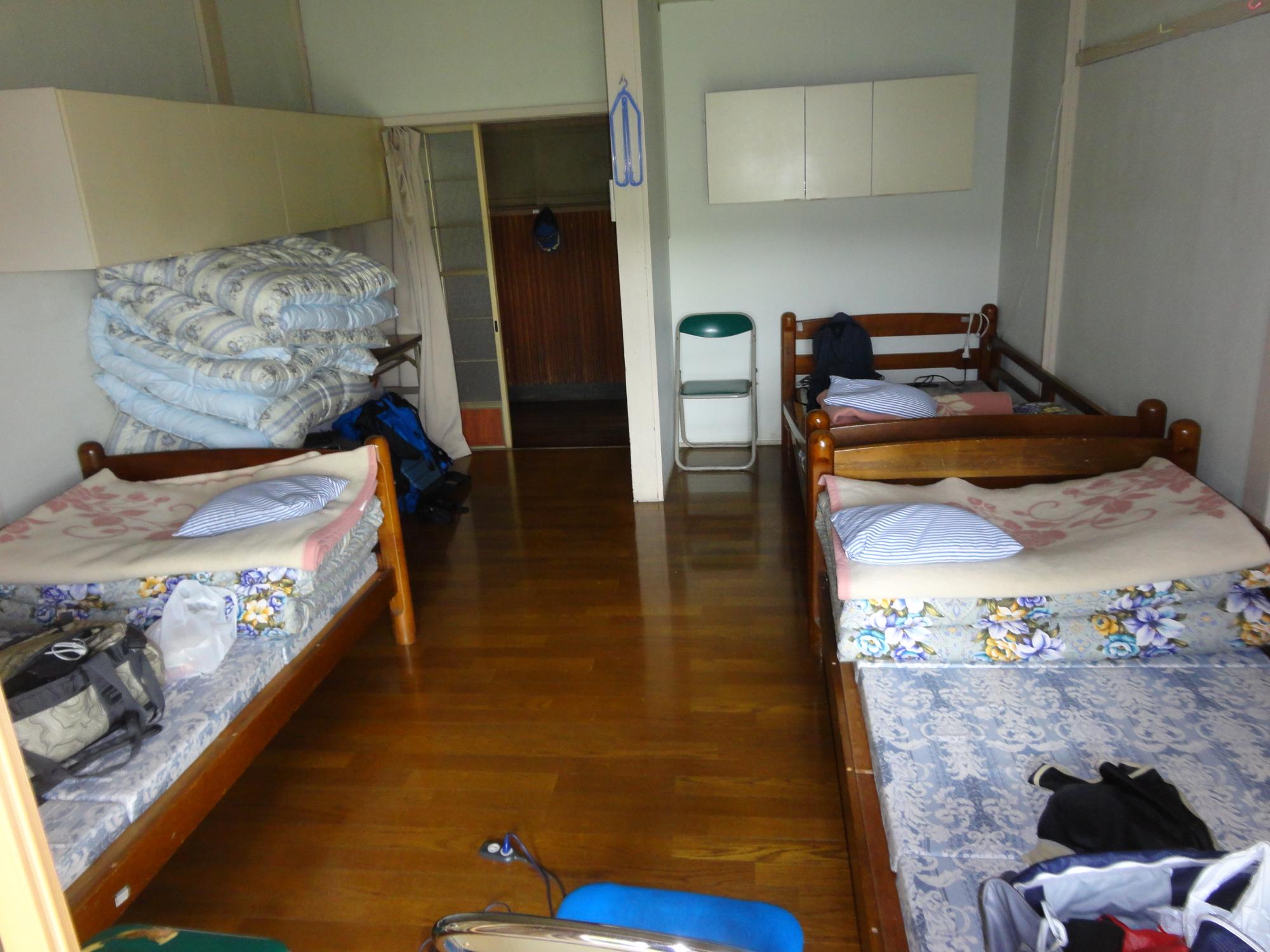 旧庁舎の仮眠室を撮影した写真で、木製ベッドが1つの居室に3台並んでいるようすを撮影