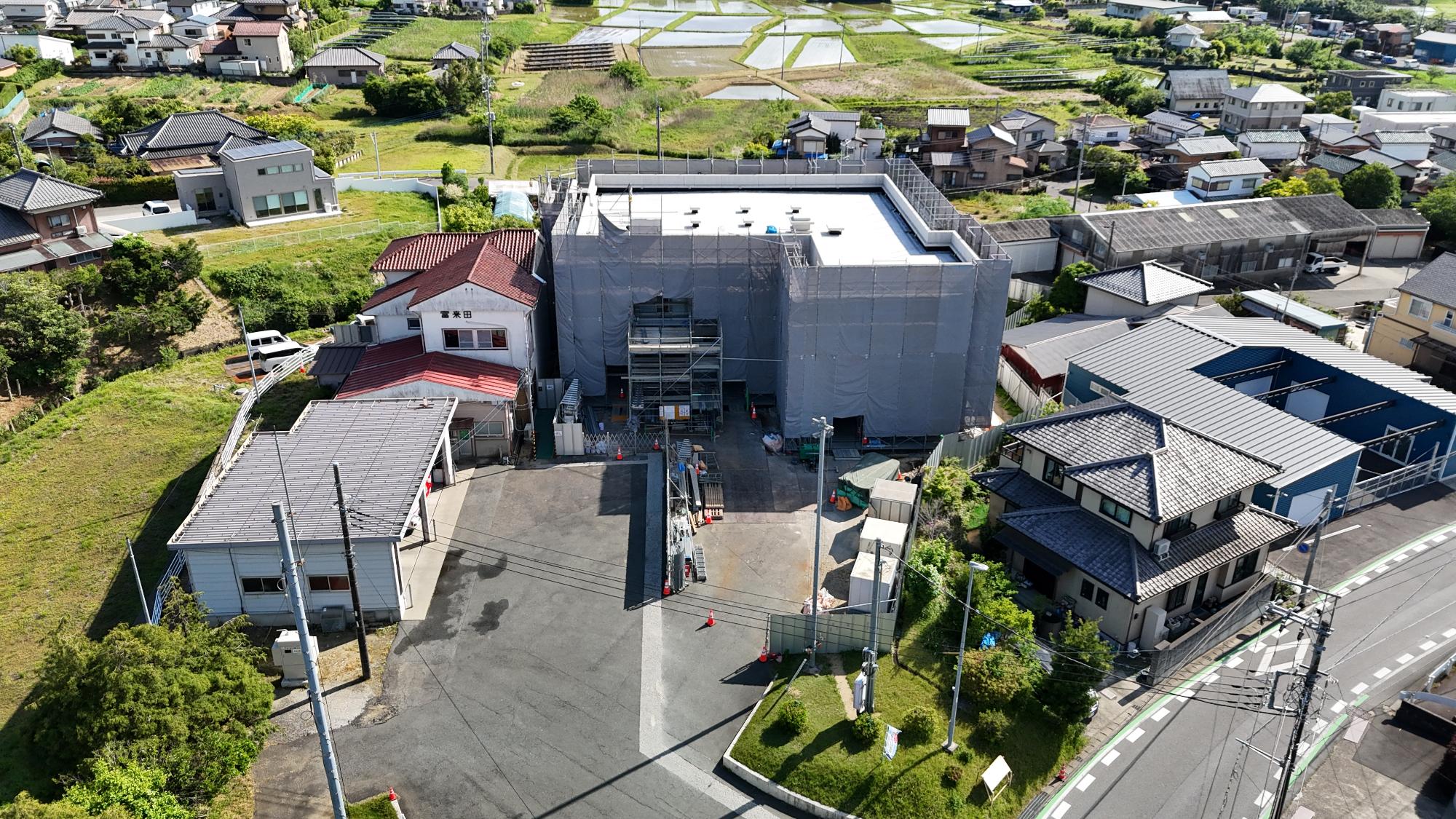 令和8年5月11日時点の工事進捗状況をドローンで撮影しており、庁舎には仮囲いがされていて外観は見えない状況である。