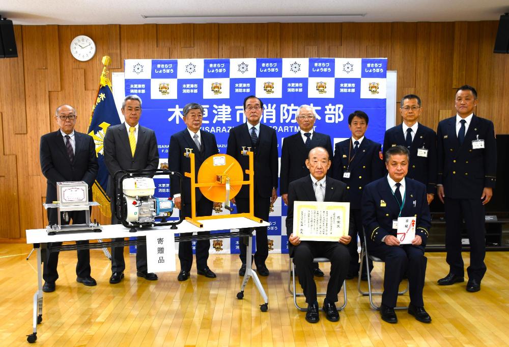 千葉県消防設備協会3名と千葉県消防設備協同組合3名と消防本部4名がホース洗浄機と一緒に写っている様子