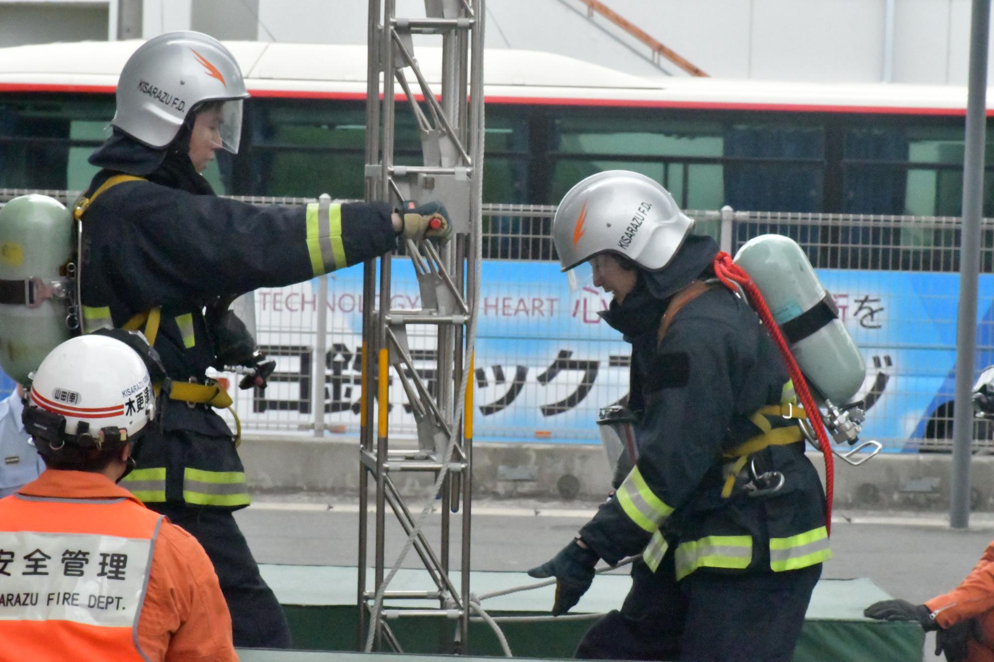 防火衣を着装し空気呼吸器を背負った新規採用消防職員が、梯子操作を実施している様子の写真