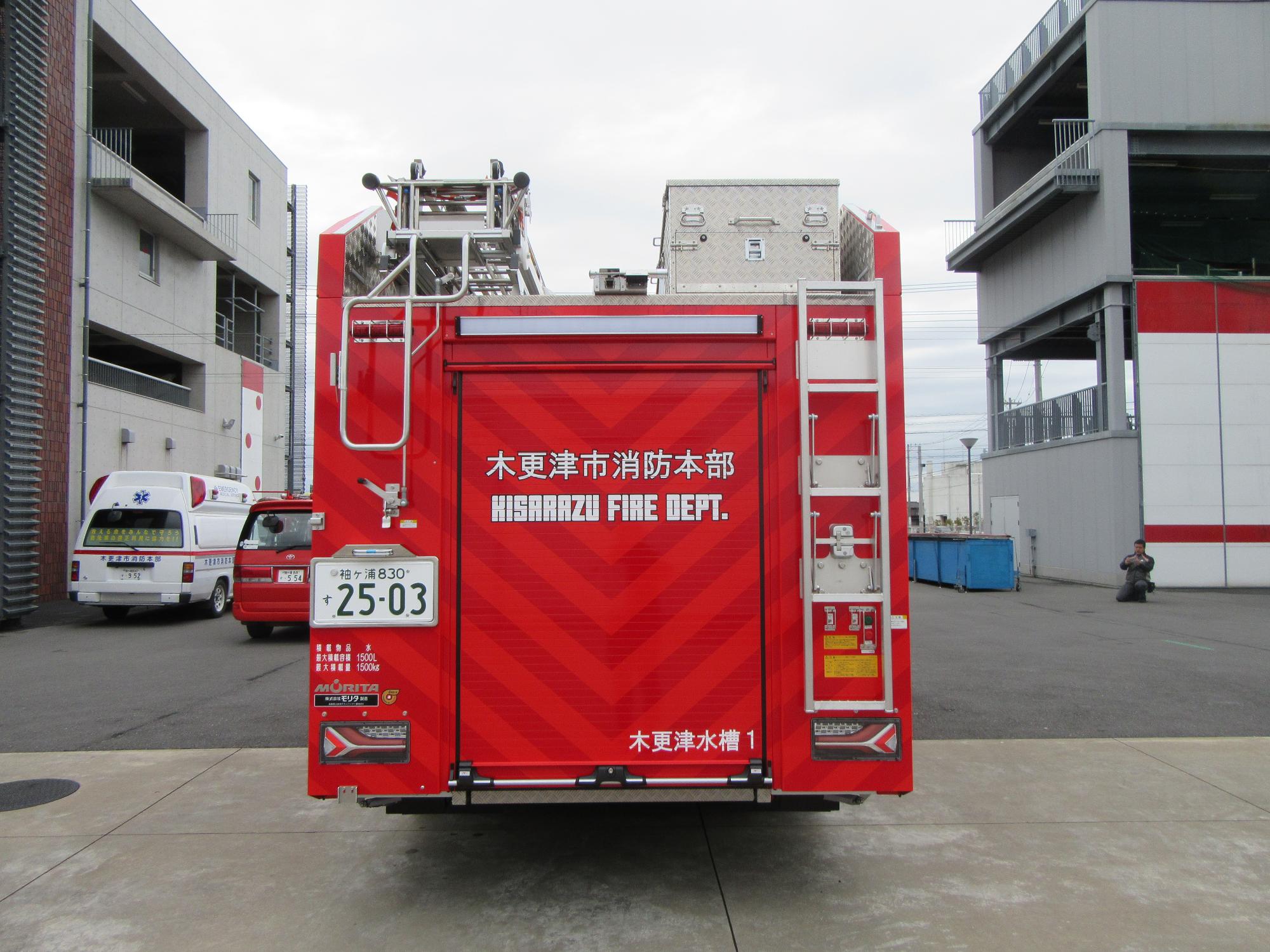 青空の下消防本部庁舎の前で令和6年度に更新した水槽付消防ポンプ自動車の後ろ側を撮影した写真