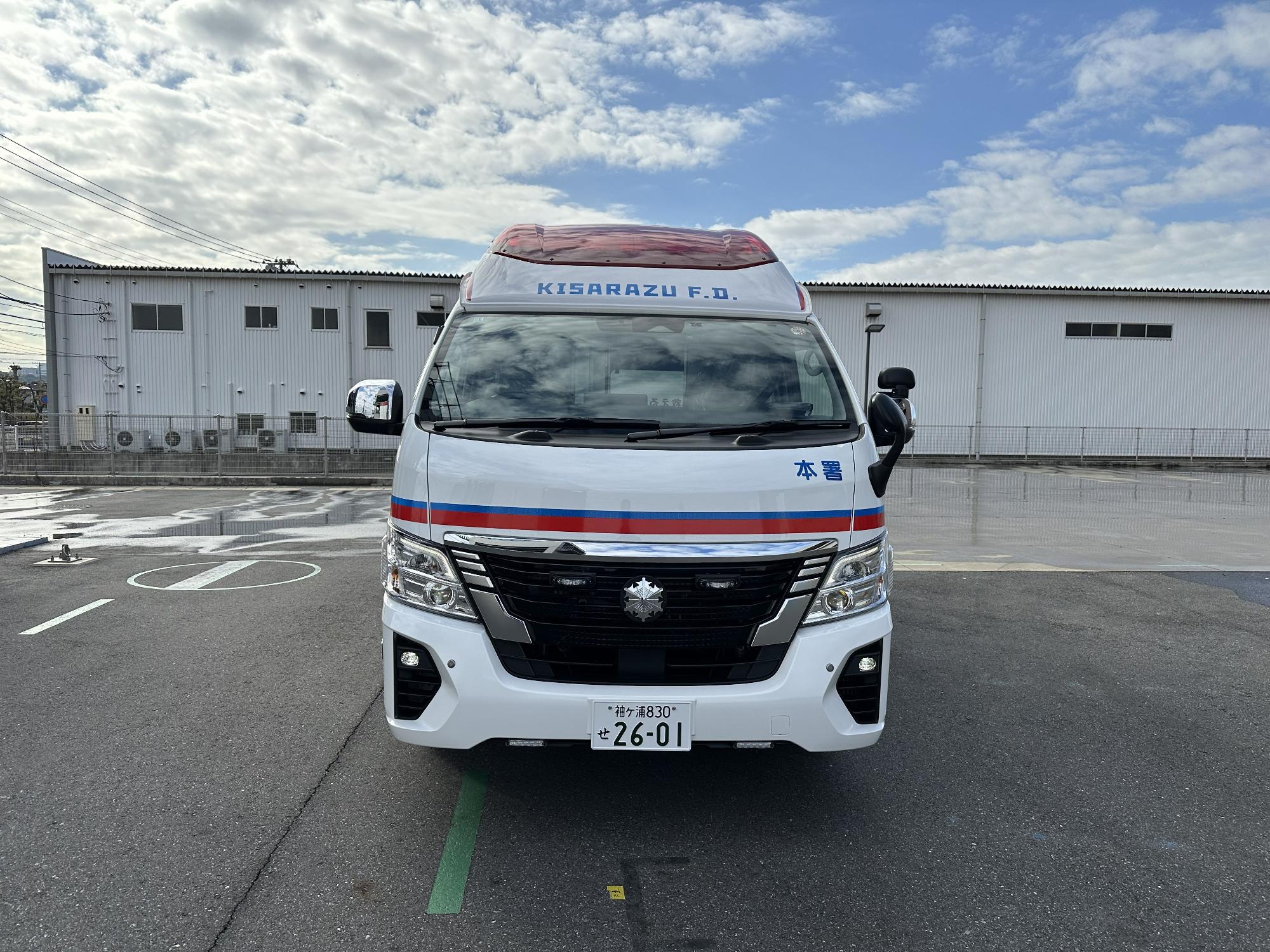 青空の下消防本部敷地内で令和7年度に更新した救急車の前側を撮影した写真