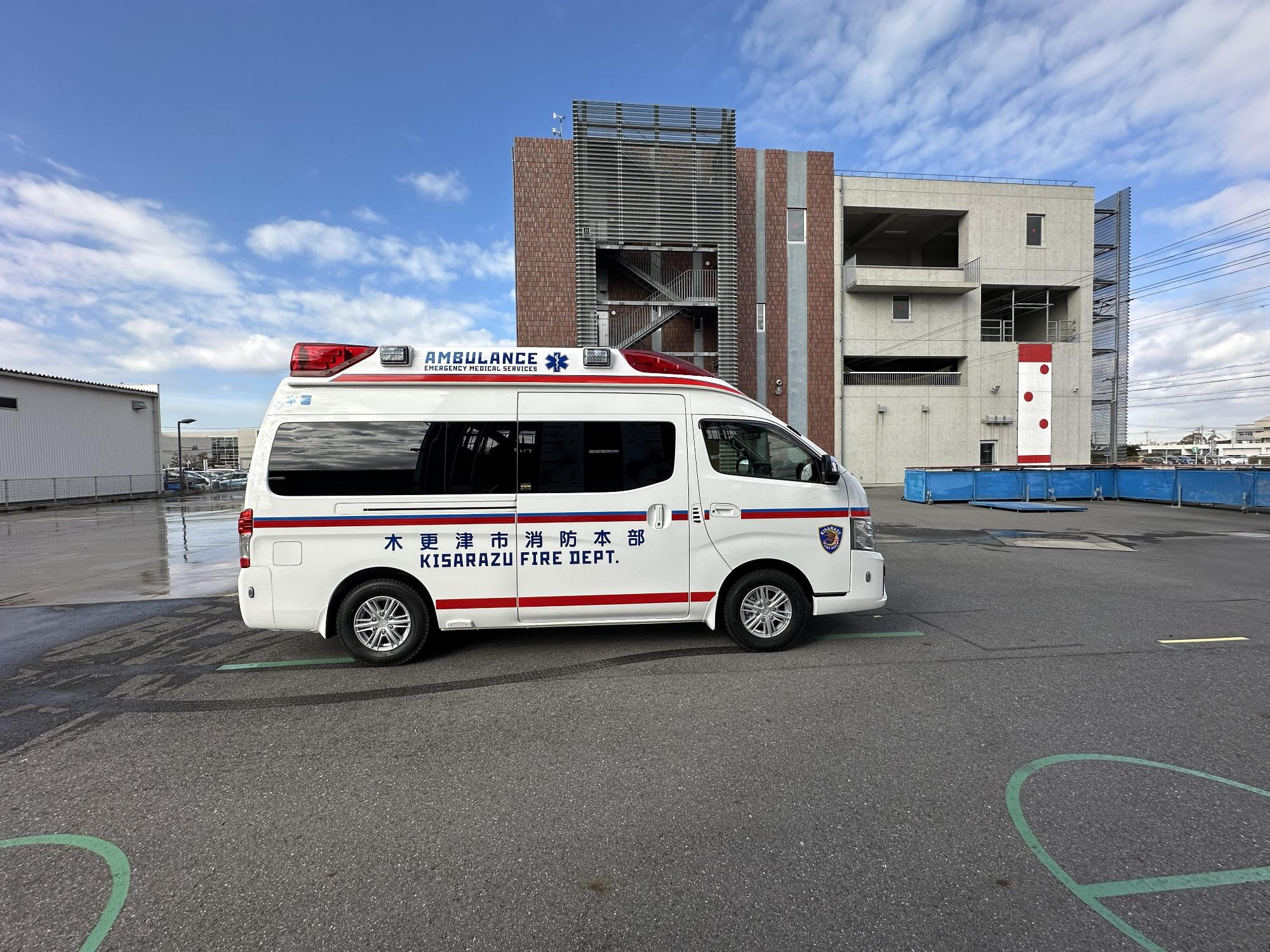 青空の下消防本部敷地内で令和7年度に更新した救急車の右側を撮影した写真