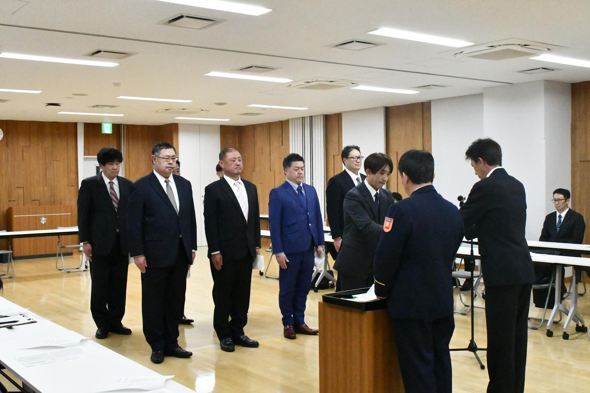 消防団の新本部長が辞令交付を受けている写真