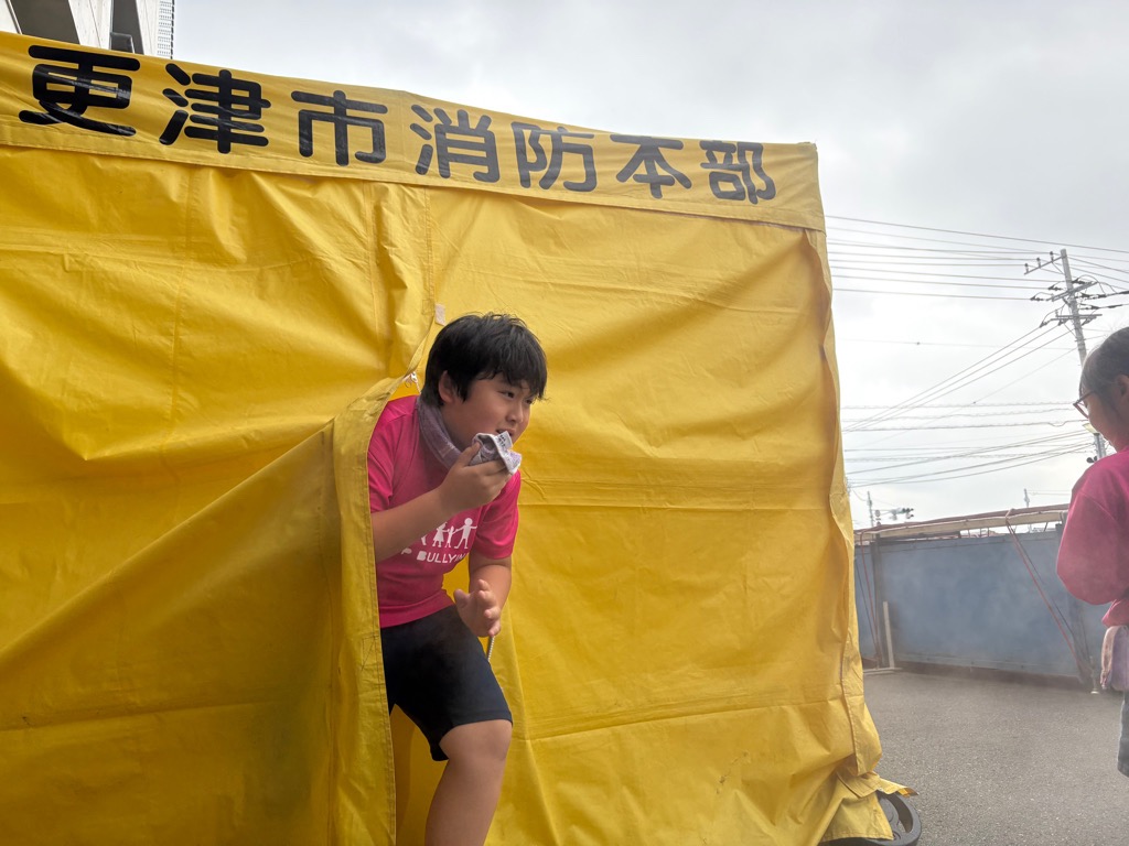 煙が充満しているテントから子供が出てきた様子
