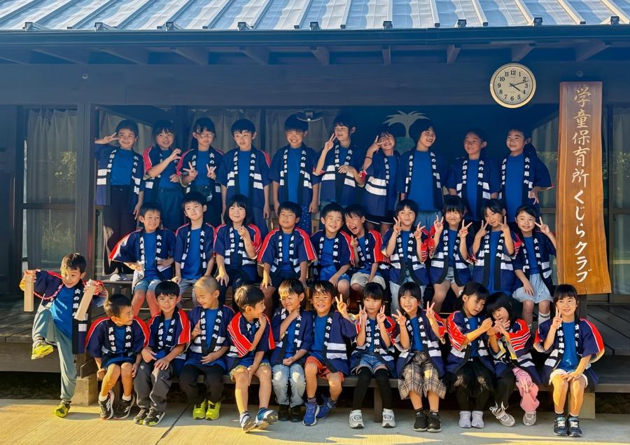 くじら少年消防クラブの子供たちが火災予防のためはっぴを着て写真撮影している様子