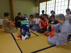 第1回教室で、子どもたちが袱紗の捌き方を講師に教わりながら練習している様子