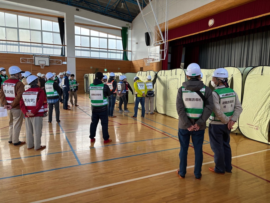 市の職員と地域の方々とが共同して体育館で避難所開設訓練を行っている様子