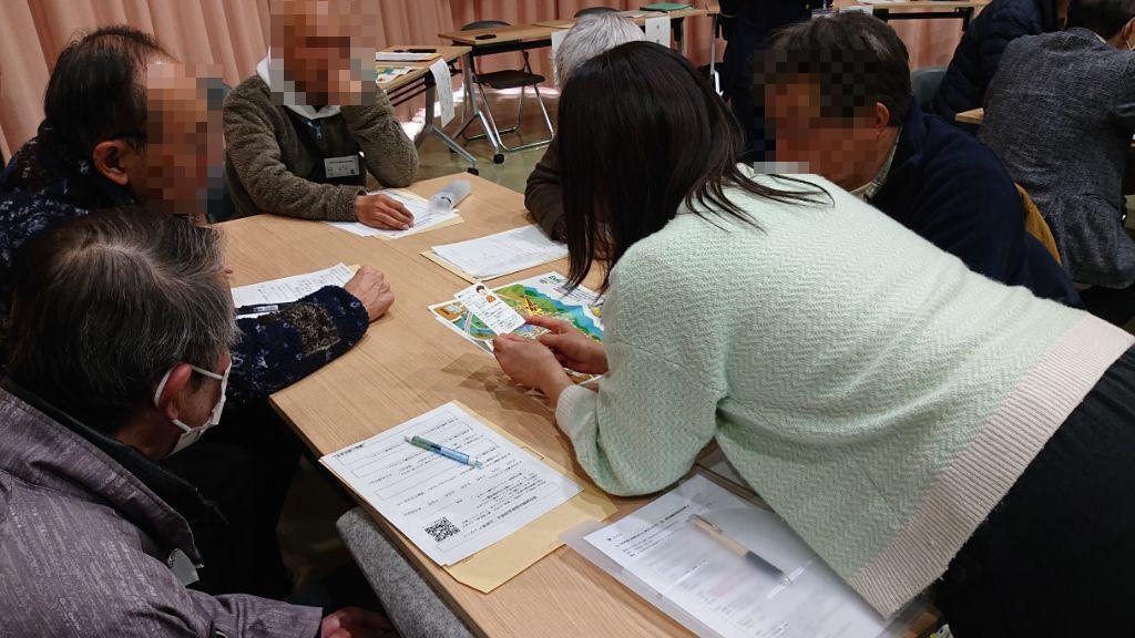 カードゲームタイプの防災教育教材を用いて、災害時の避難行動を疑似体験できるワークショップを行い、災害時に避難行動を行う際の課題について話し合っている参加者の様子になります。