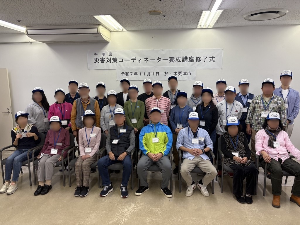 参加者が三列に並び集合写真を撮っている様子