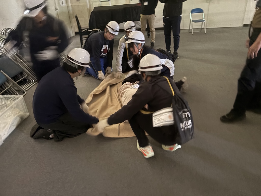 地震災害の現場を想定し、負傷者の搬送準備を行う様子です。